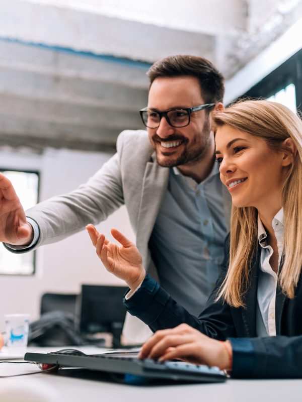 Working together on project. Two young business colleagues working on computer